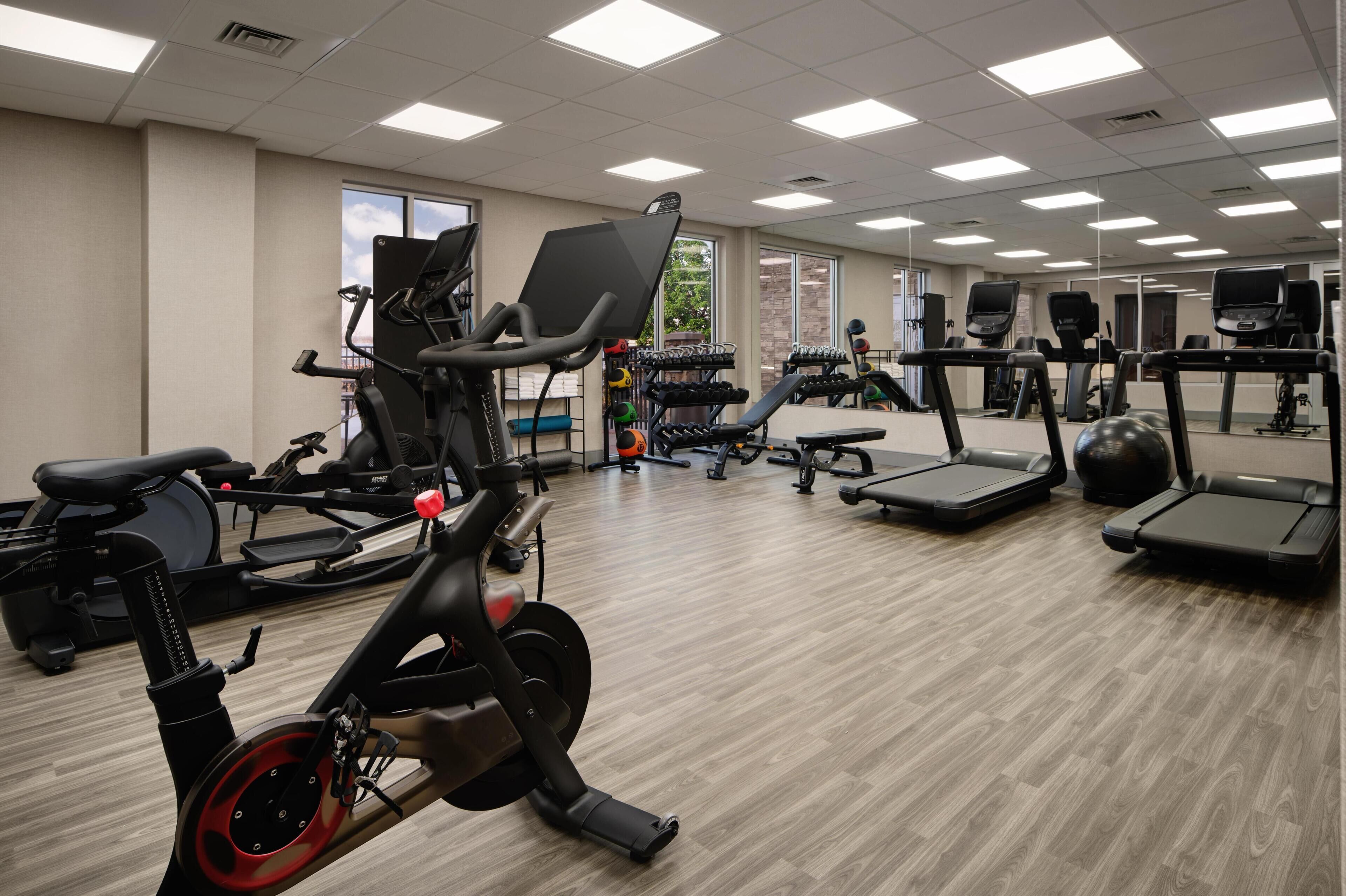 Un gimnasio con bicicletas estáticas, cintas de correr y máquinas de pesas.