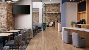 Ein modernes Interieur mit Steinwand, Flachbildfernseher, Barbereich und Sitzgelegenheiten.