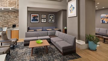 Un área de descanso moderna con un sofá modular, una mesa de centro y una planta en maceta.