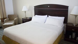 A hotel room with a large bed, two bedside tables, a chair, and a lamp. - Holiday Inn Express West Jefferson by IHG (West Jefferson)