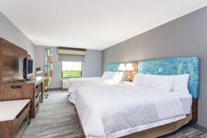 A hotel room with two beds, a desk with a computer, a TV, and a window with a view of greenery. - Hampton Inn Auburn (Auburn)
