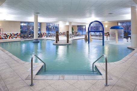 Una piscina techada, sillones reclinables de piscina