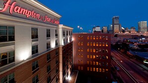 A hotel with a prominent sign, multiple floors, and a cityscape in the background.