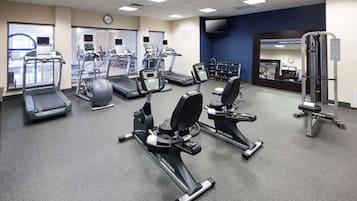 A gym with treadmills, elliptical machines, and weightlifting equipment.