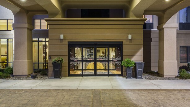A hotel entrance with a double door, a tiled floor, and potted plants. - Hampton Inn & Suites by Hilton Walla Walla (Walla Walla)