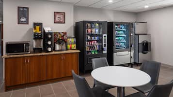 Une petite cuisine équipée d’un four à micro-ondes, d’une machine à café et de distributeurs automatiques.