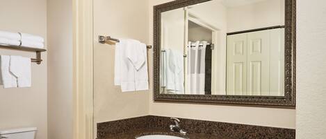 A bathroom with a sink, mirror, towel rack, and toilet.