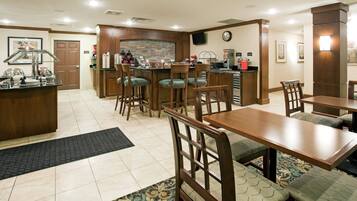 A restaurant with a bar area, multiple seating options including booths and high chairs, and a tiled floor.