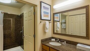 A bathroom with a bathtub, a shower, a sink, and a large mirror.