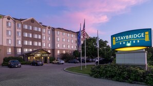 Ein Staybridge Suites Hotel mit Ziegelaußenwand, mehreren Fenstern und einem gut beleuchteten Eingang.