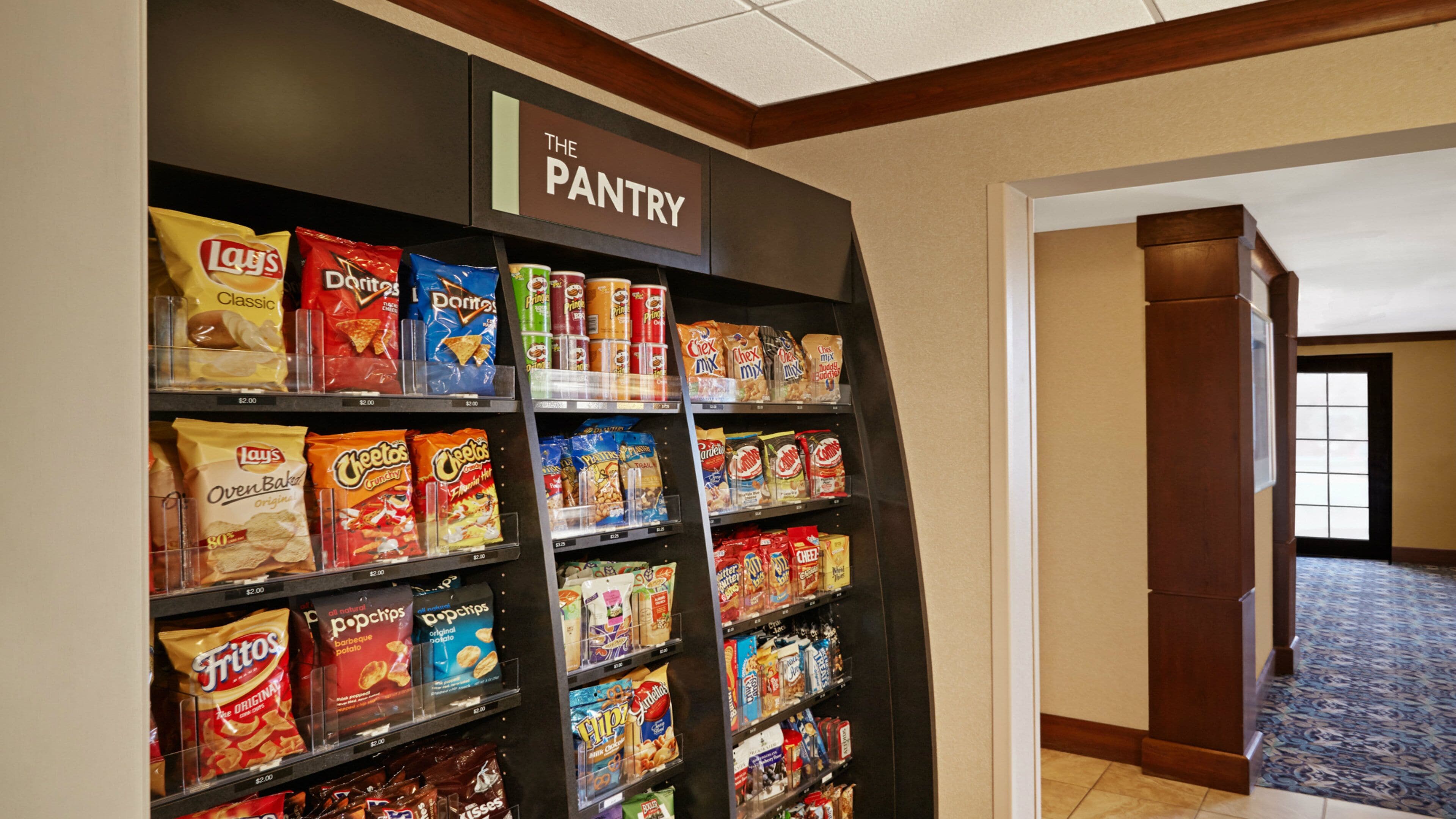 A pantry with shelves stocked with various snacks and food items.
