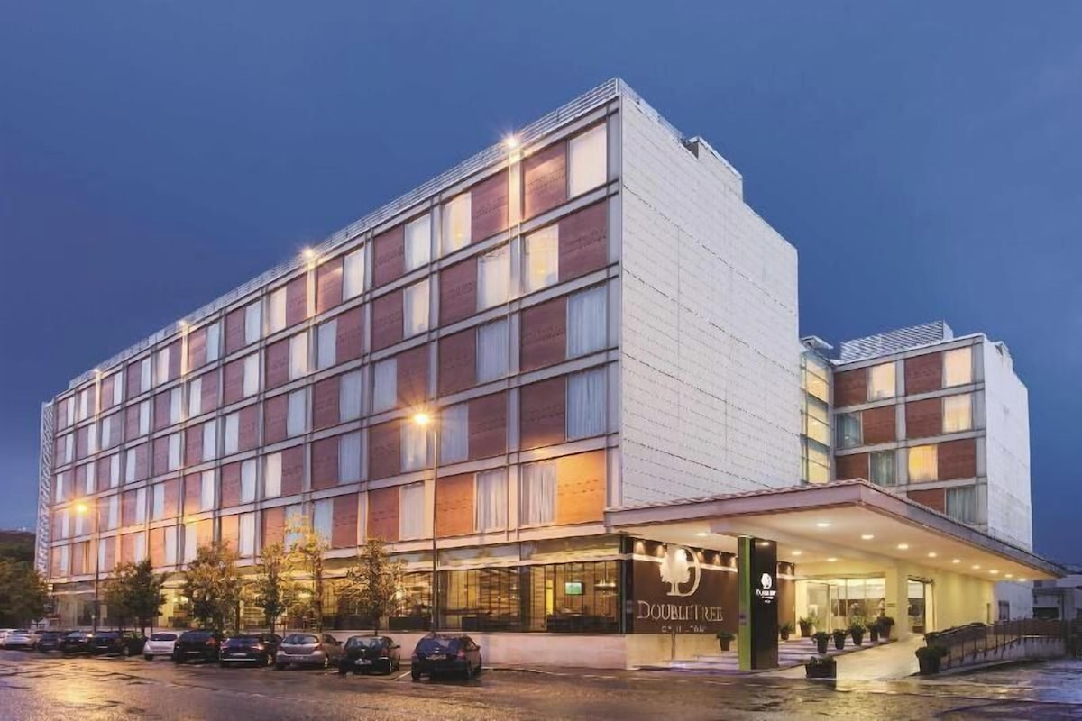Un hotel de varios pisos con fachada moderna, grandes ventanales y una entrada bien iluminada.