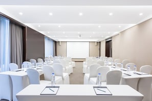 A conference room with rows of white chairs, tables with water bottles, and a projector screen at the front. - Holiday Inn Express Beijing Temple of Heaven by IHG (Beijing)