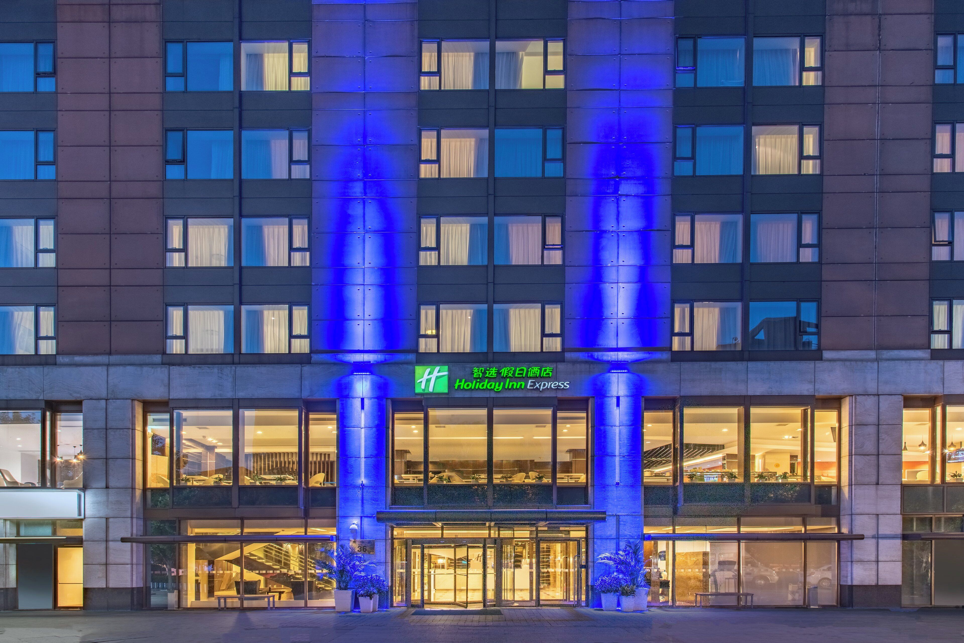 A hotel with a modern facade, large windows, and a prominent entrance with a glass door.