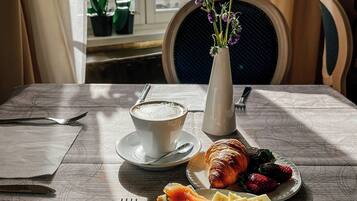 Ein Tisch mit Mahlzeit, einer Kaffeetasse und einer Vase mit Blumen.