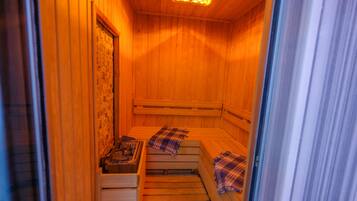 Een sauna met houten banken en een stenen muur.