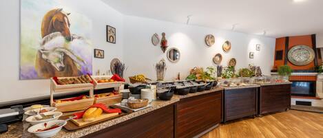 A buffet setup with various food items and decorative plates on a wooden counter.