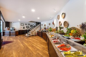 Una cocina moderna con suelo de madera, una isla empotrada con fregadero y una escalera que sube a otro nivel.