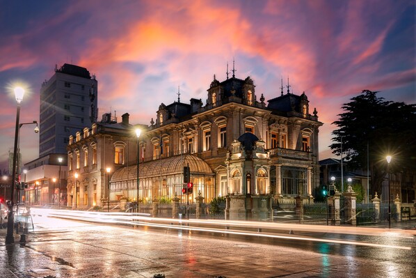 Un edificio histórico con arquitectura clásica, ventanas amplias y una cúpula destacada.