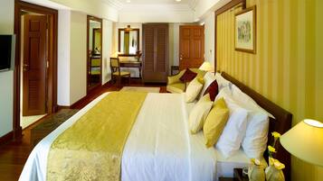 A hotel room with a large bed, a desk, and a chair.
