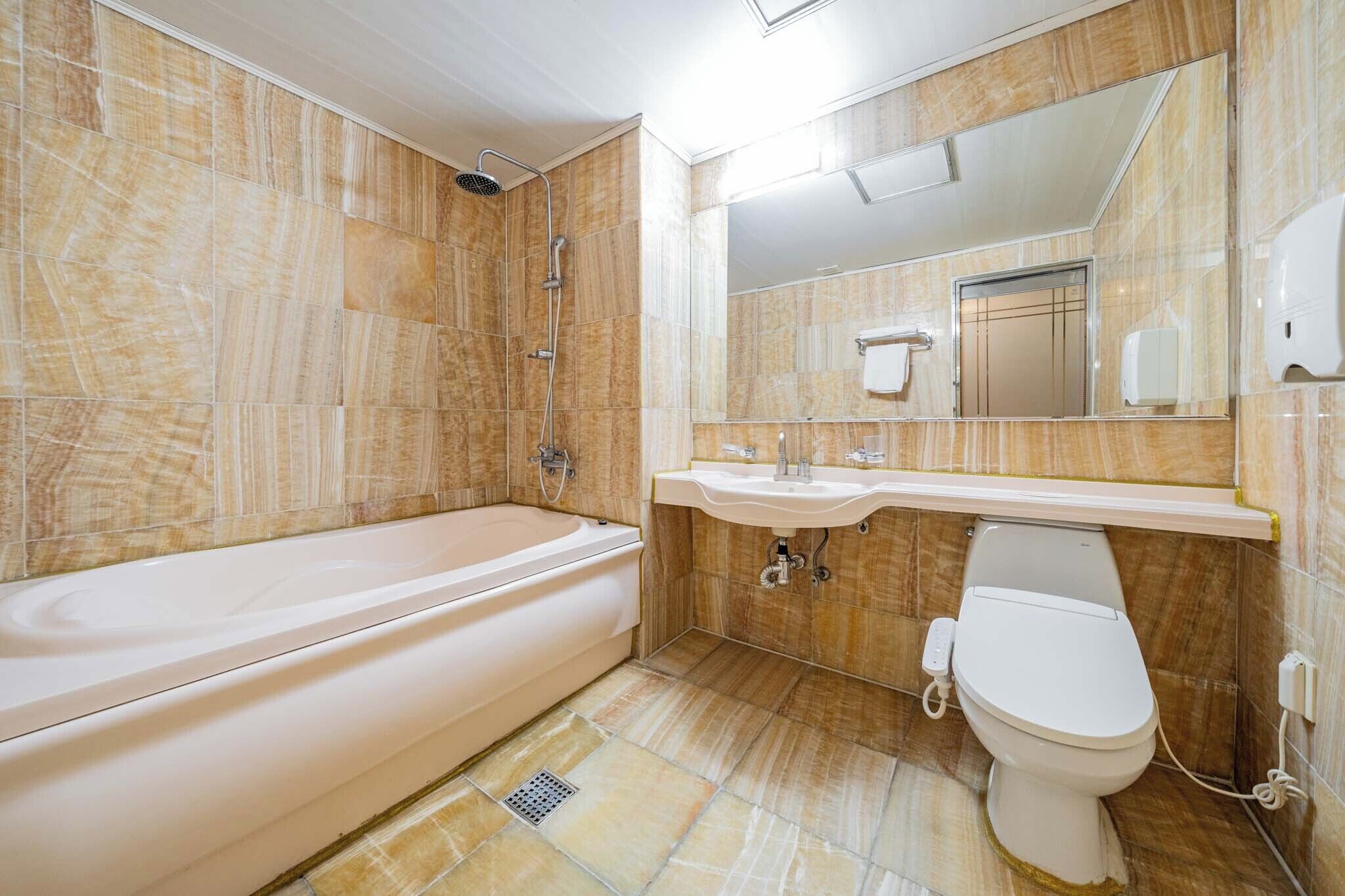 Une salle de bain avec une baignoire, un lavabo, des toilettes et une douche.