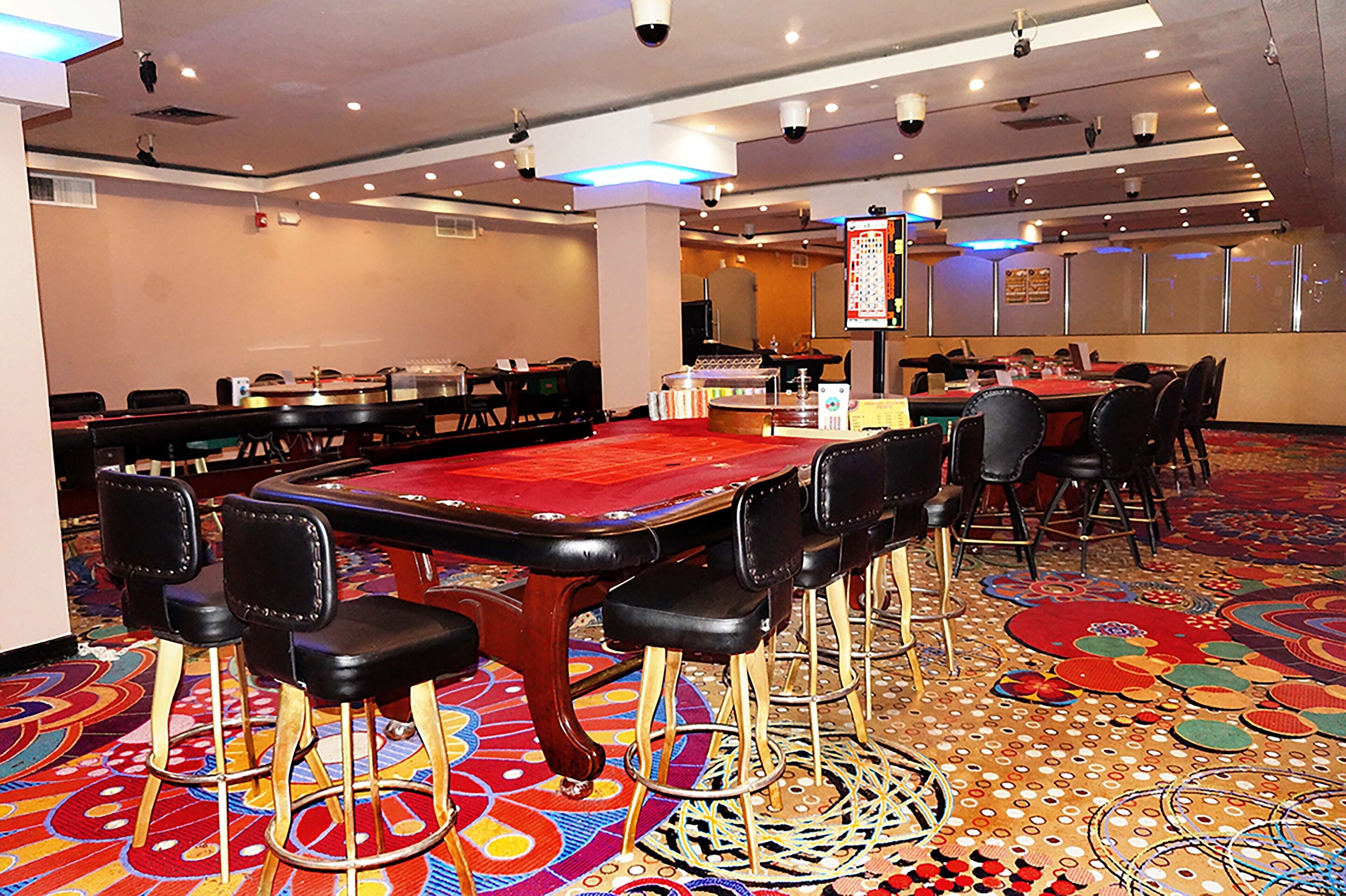 A room with a pool table, multiple chairs, and a carpeted floor.