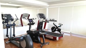 A gym with cardio machines, a stationary bike, and a treadmill.