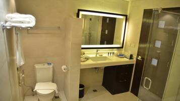 Un baño moderno con inodoro, lavamanos y cabina de ducha de vidrio.