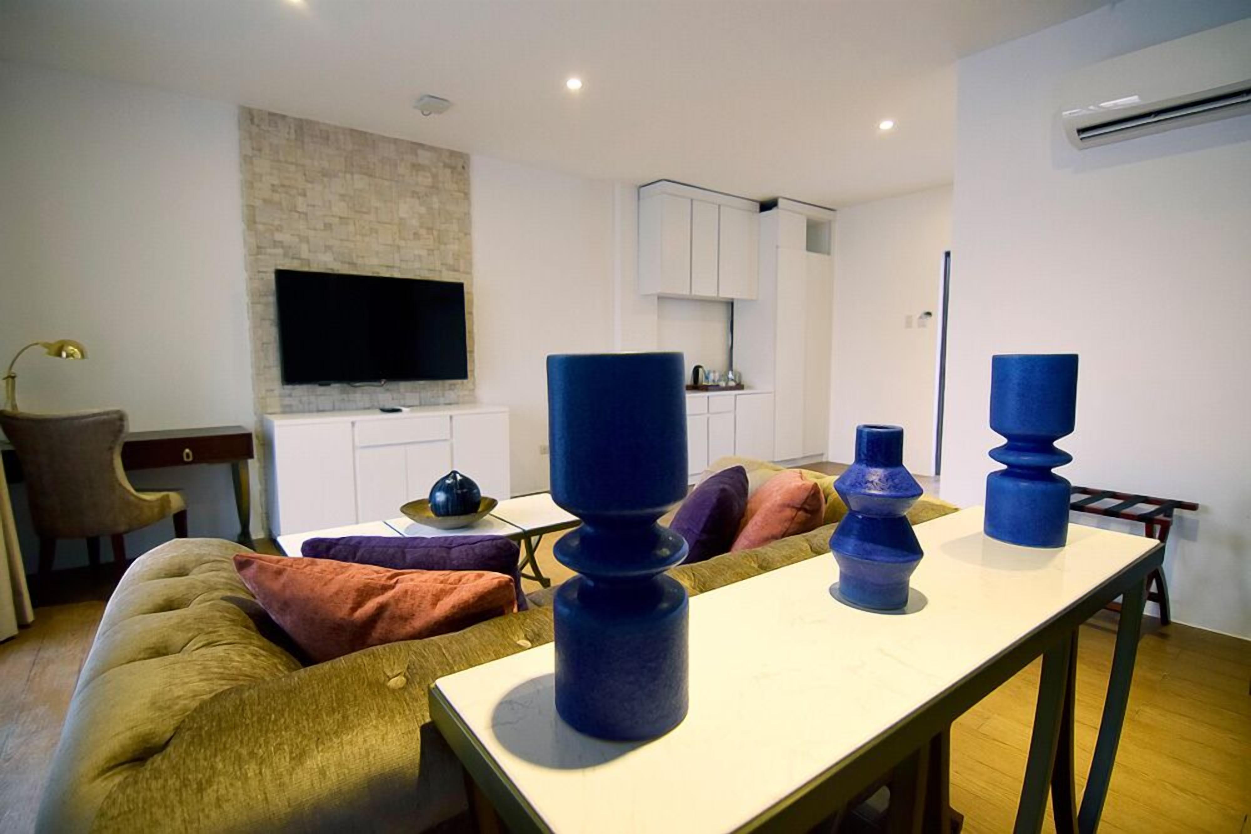 Een moderne woonkamer met een bank, een salontafel en decoratieve vazen.
