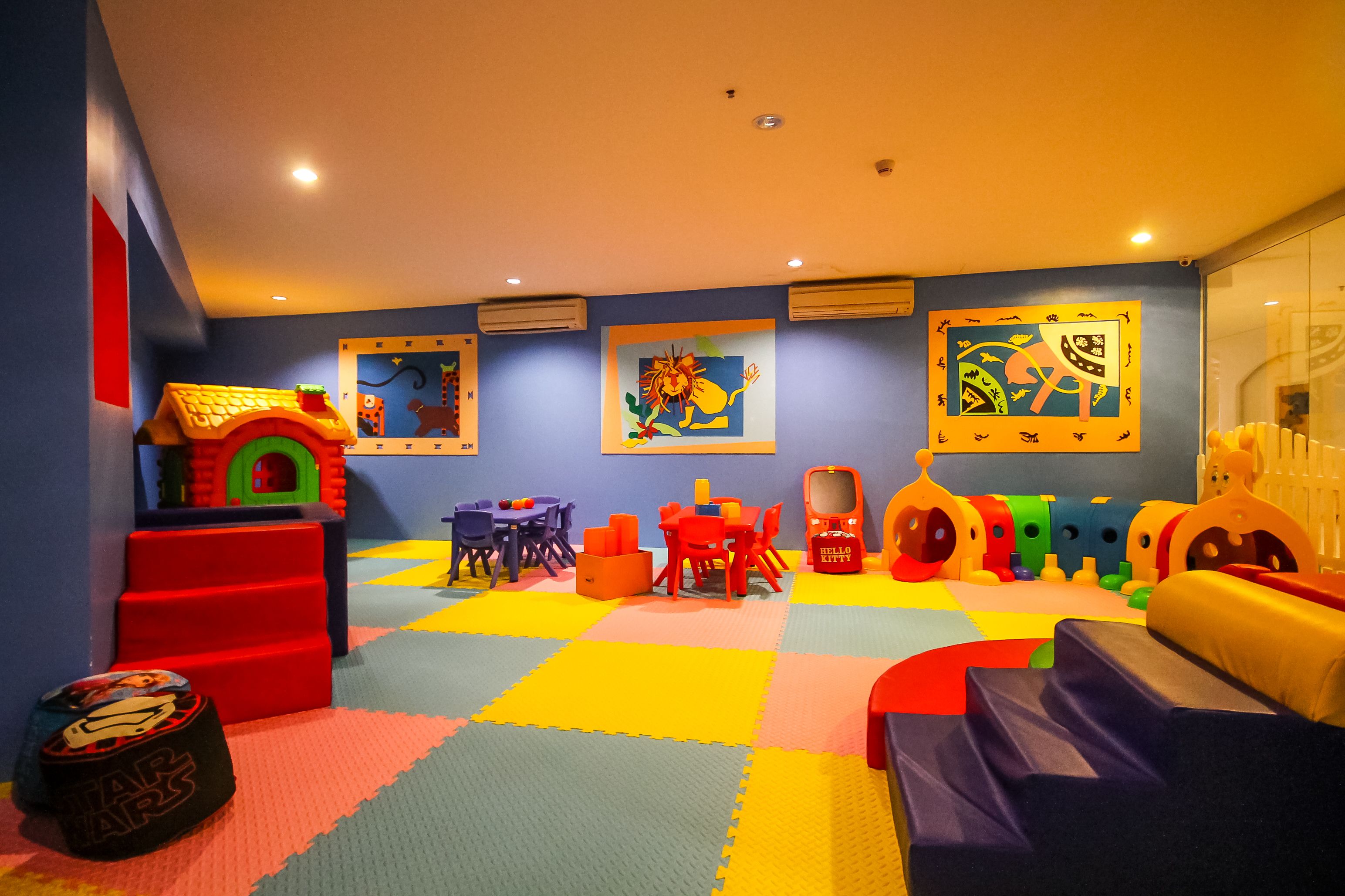 A children's play area with colorful play mats, a playhouse, and various toys.