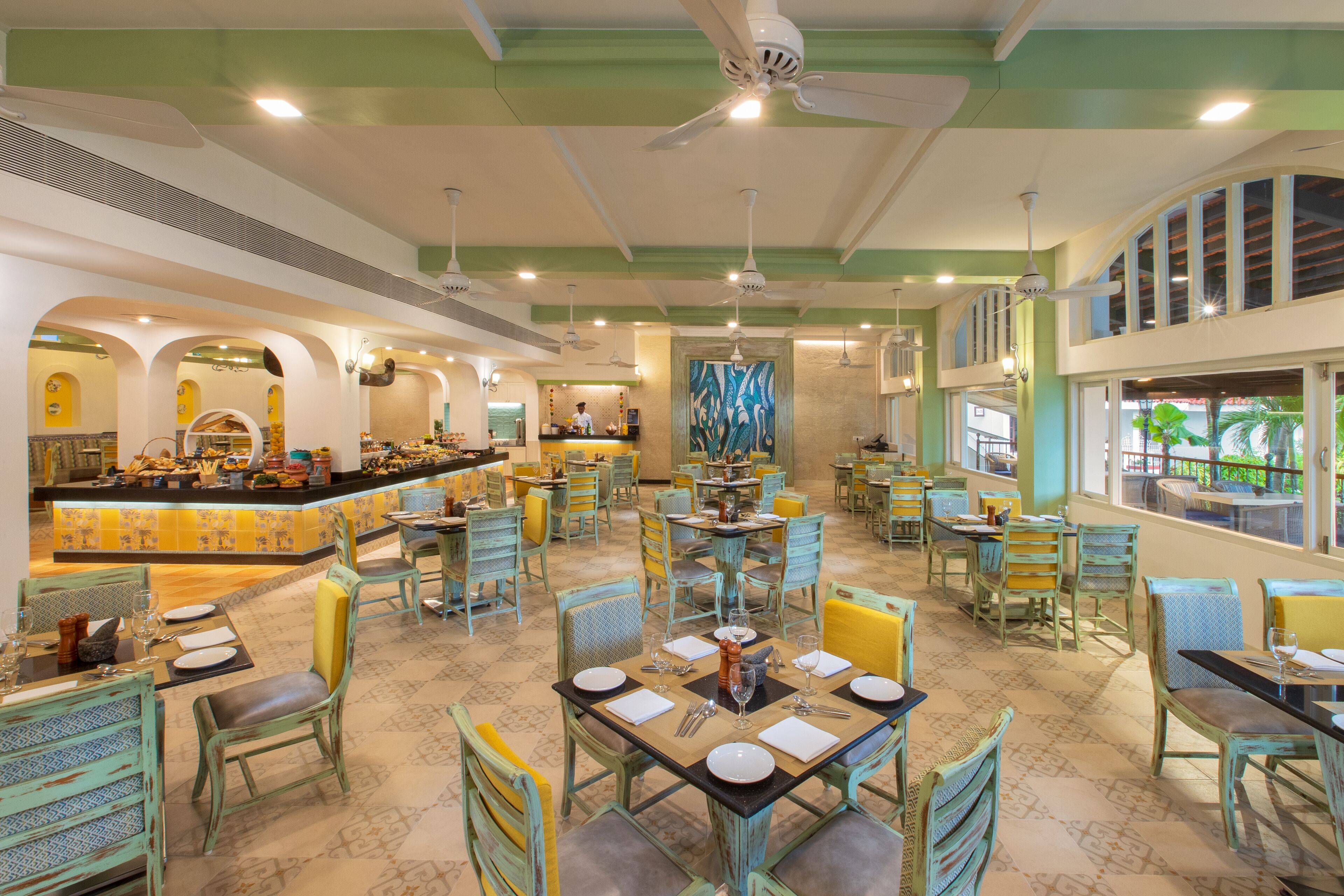 A spacious restaurant with multiple dining areas, a bar, and a view of the outdoors.