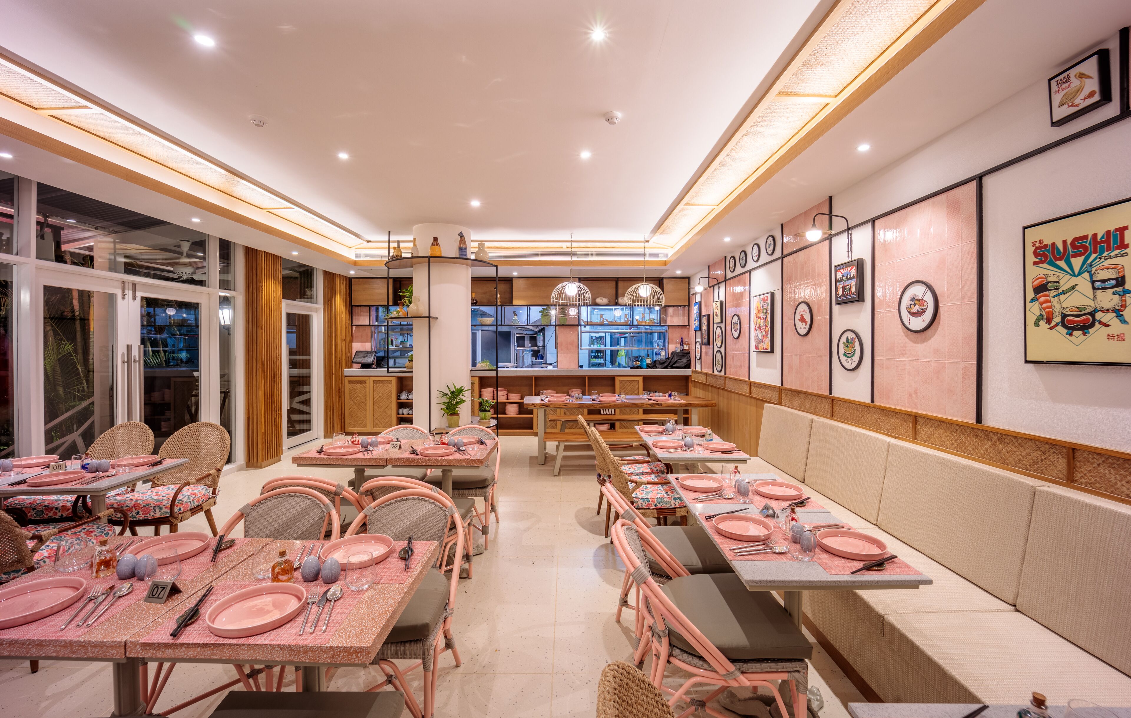 Ein Restaurant mit gedeckten Tischen, einer Wand im Sushi-Design und Blick auf die Straße.