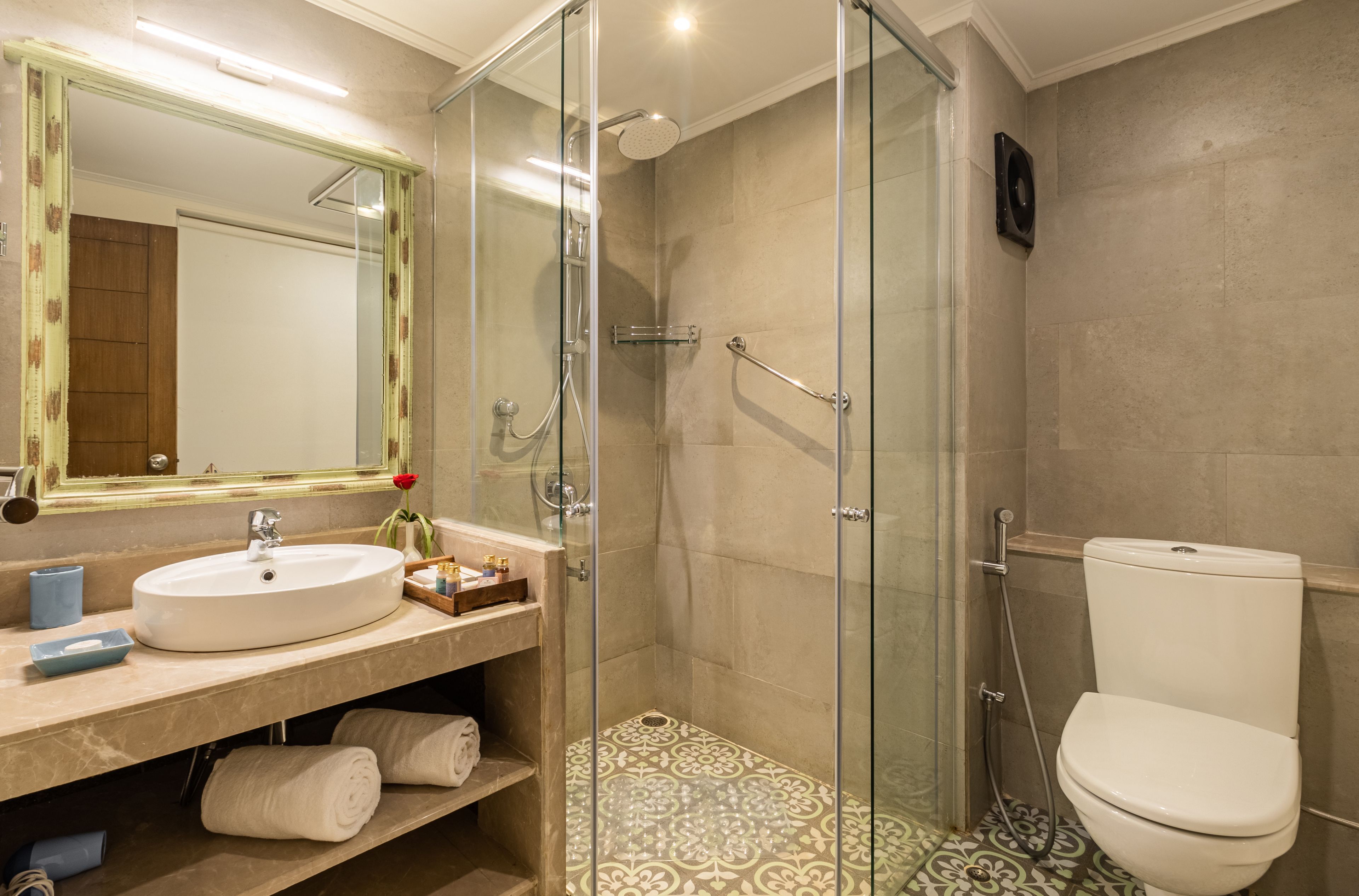 Un baño moderno con ducha envuelta en vidrio, un lavabo blanco y un inodoro.