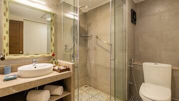 Un baño moderno con ducha envuelta en vidrio, un lavabo blanco y un inodoro.