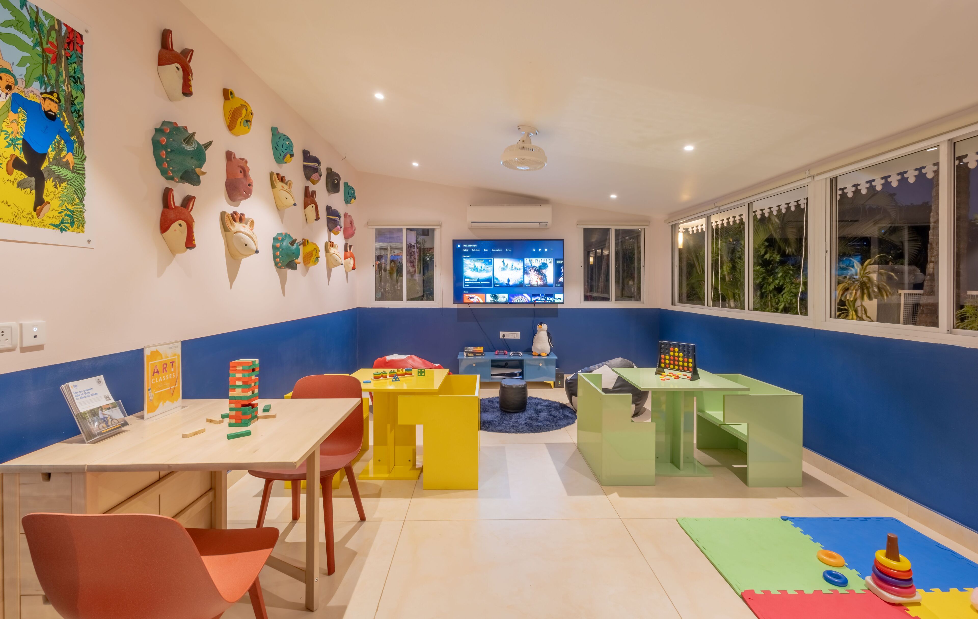 A brightly colored children's playroom with a TV, toys, and educational materials.
