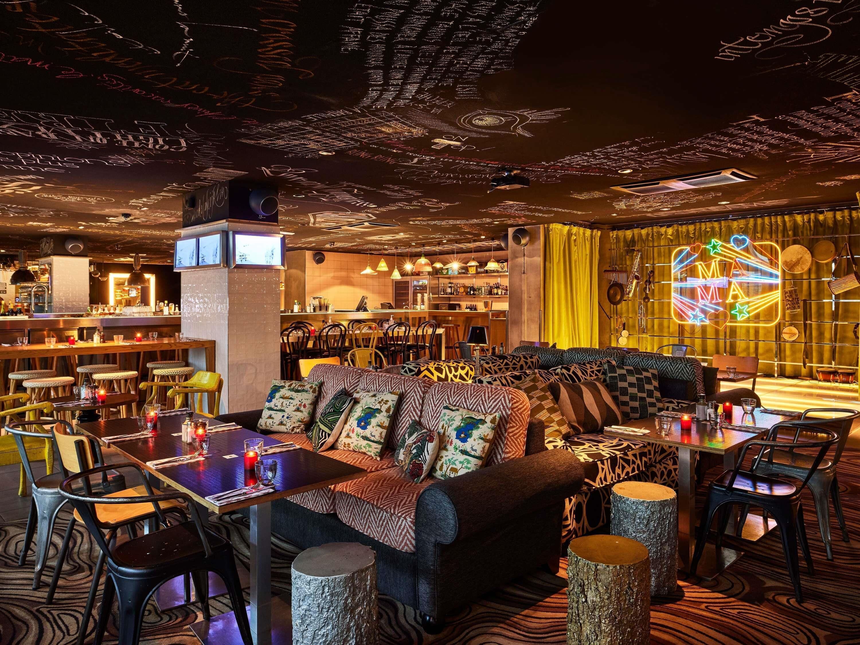 A cozy bar area with a sofa, chairs, and a bar counter.