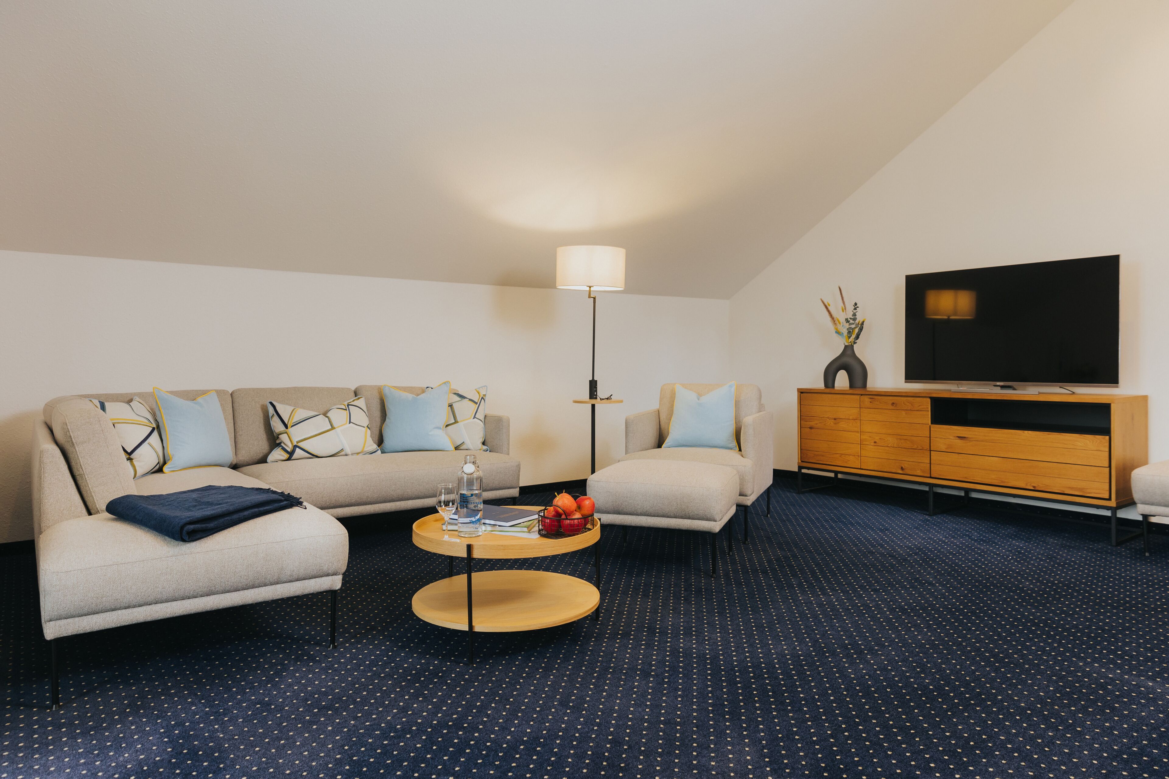 Ein modernes Wohnzimmer mit einer Couch, einem Couchtisch und einem Flachbildfernseher.
