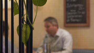 Ein Restaurantinnenraum mit unscharfem Hintergrund einer Person, die an einem Tisch sitzt.