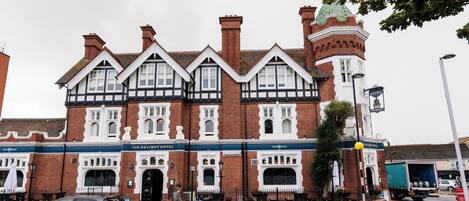 Un edificio histórico con una torre destacada y un cartel que dice 'The Railway Hotel'.