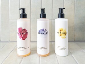 Three bottles of Brambley body wash, shampoo, and conditioner on a tiled surface. - The Railway Hotel Worthing (Worthing)