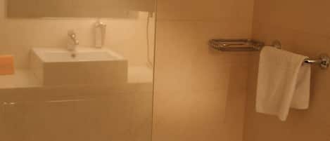 A bathroom with a sink, mirror, and towel rack.