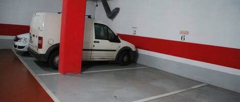 A parking garage with a white van parked in a space marked with the number 6.