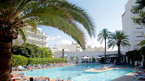 A pool area with lounge chairs and palm trees. - Hotel Tropical (Sant Antoni de Portmany)