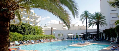 Una piscina al aire libre, sombrillas, tumbonas