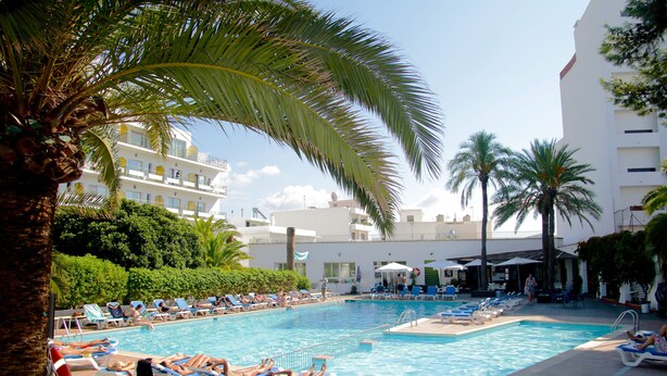 A pool area with lounge chairs and palm trees. - Hotel Tropical (Sant Antoni de Portmany)
