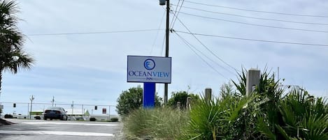 Letrero del OceanView Inn, con un cielo despejado y líneas eléctricas al fondo.