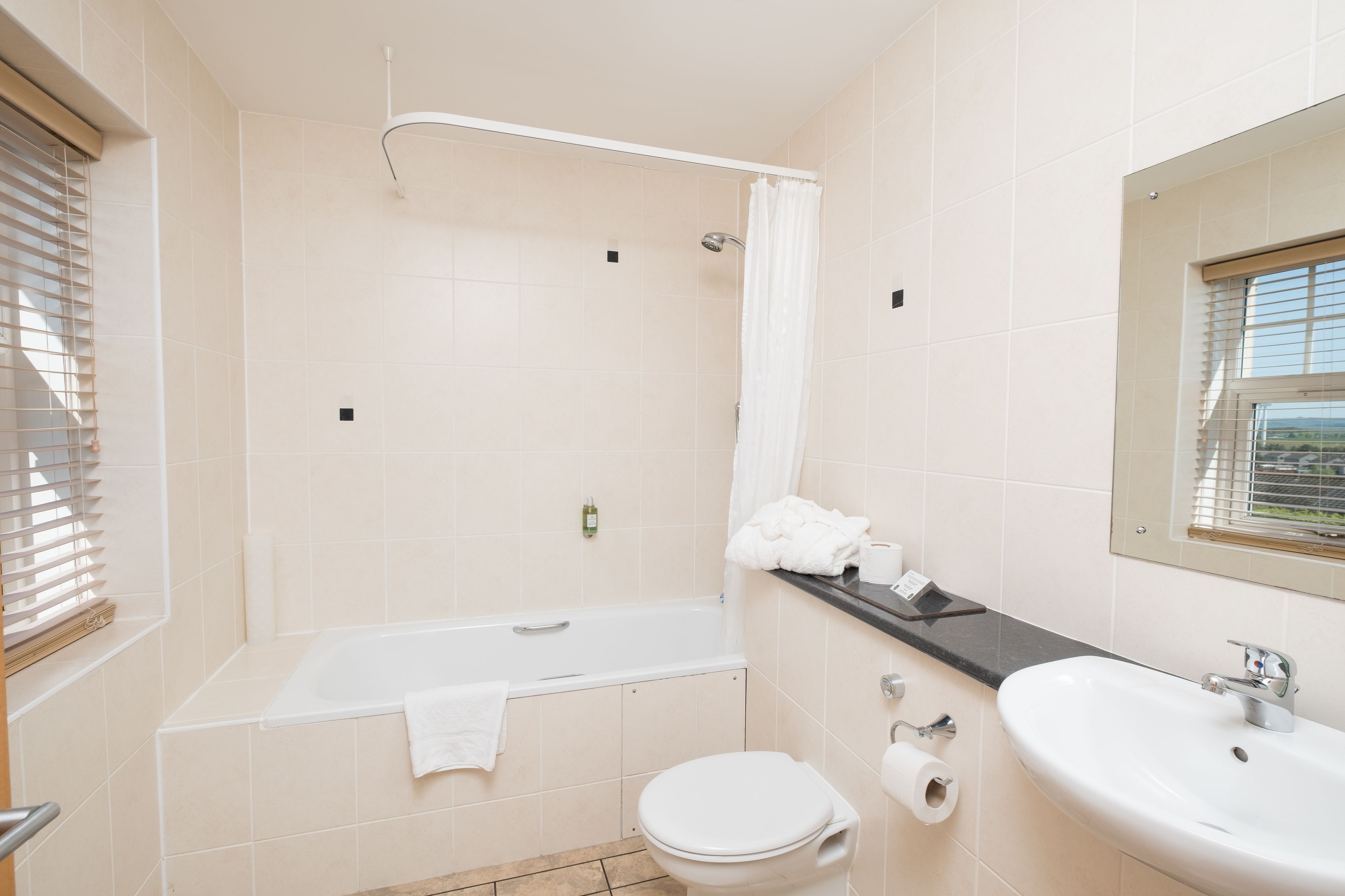 Un baño con bañera, inodoro y lavamanos.