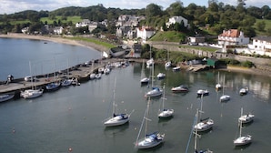 A marina with multiple boats docked, surrounded by houses and greenery.
