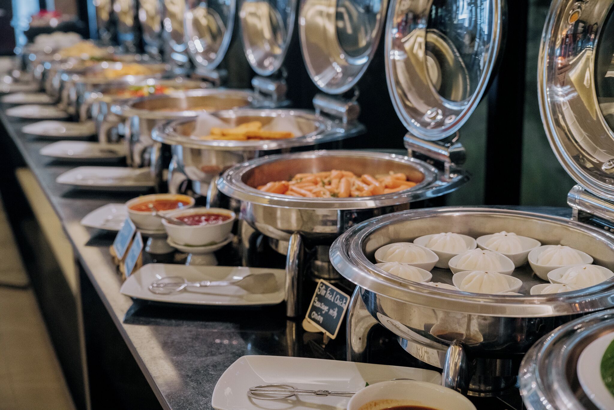 Een buffet met diverse gerechten, waaronder pasta, soep en dumplings.