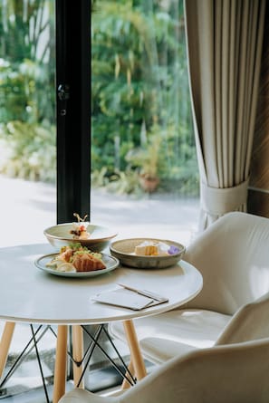 Una mesa de comedor con platos de comida, un cuaderno y un bolígrafo.